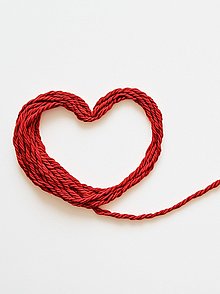 Ein roter Faden der zu einem Herz gelegt ist